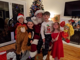 Children showing off puppets and gifts from Santa Dale