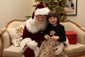 Smile for the Camera - Santa Dale with young girl in Christmas dress